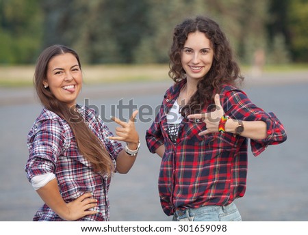 Two young woman making fun on nature at sunset