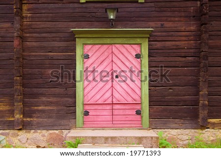 A entrance with a pink door on an old house