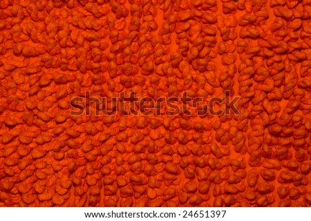 Close-up of an orange indoor warm and soft carpet.