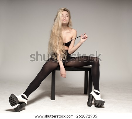 Young European attractive sexy fashion model with long blond natural hair, beautiful eyes, full lips, perfect skin is posing in studio for glamour vogue test photo shoot