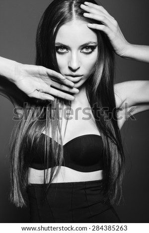 Awesome caucasian attractive sexy fashion model with long brunette natural hair, beautiful eyes, full lips, perfect skin posing  in studio, touching face, beauty photo shoot, retouched image