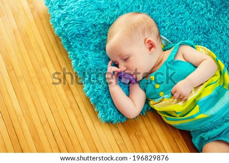 2 month old baby girl sleeping on a furry pillow and bamboo rug--image taken indoors using natural light (Reno, Nevada, USA)