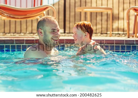 Father playing with his 2 year old son in the pool -- image taken in Reno, Nevada, USA