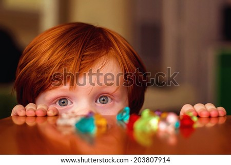 4 year old boy playing at a wooden table with toy gems -- image taken indoors in Reno, Nevada, USA
