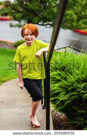 7 year old boy playing outside in the rain -- image taken in Reno, Nevada, USA