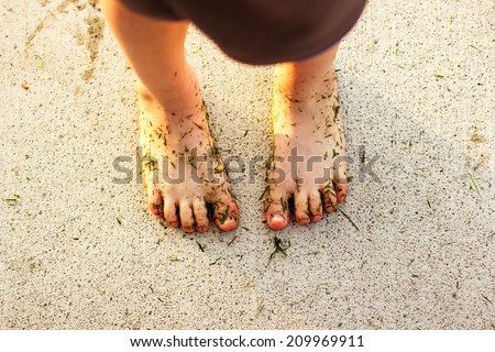 4 year old boy\'s feet covered in wet grass while playing outside -- image taken in Reno, Nevada, USA