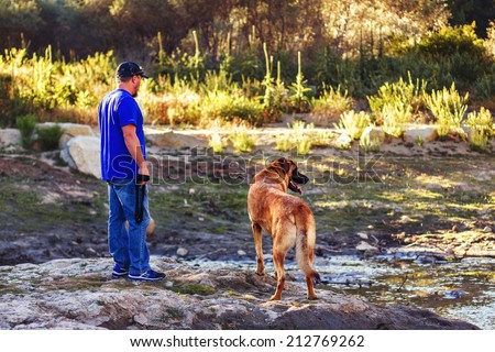 Man playing with his 5 year old german shepherd mastiff dog -- image taken at Davis Creek Regional Park in Reno, Nevada, USA