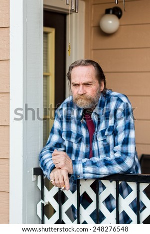 Older man standing on his patio smoking a cigarette in Reno, Nevada, USA