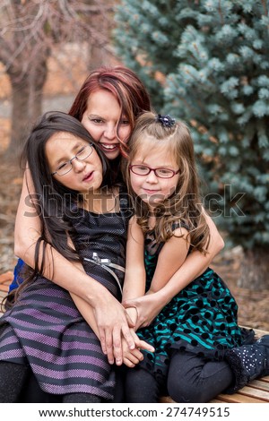 Mother playing with her young daughters outside at a park in Reno, Nevada, USA.