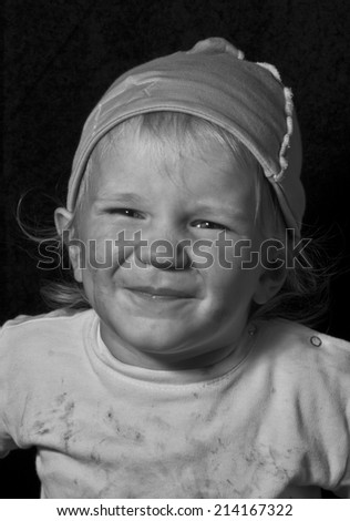 poor laughing child, black and white portrait on black