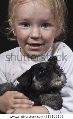 smiling  poor child embracing a puppy