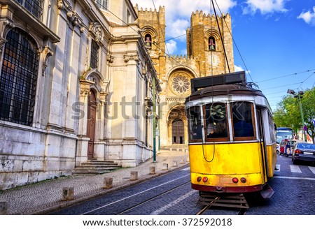 Historical yellow tram in front of the Lisbon cathedral, Alfama, Lisbon, Portugal