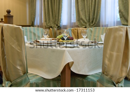 Table with chairs prepared for dinner in restaurant