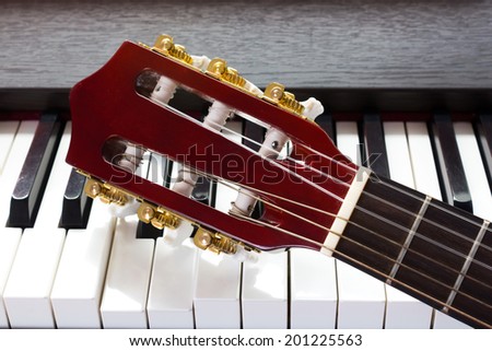 guitar neck on piano keys