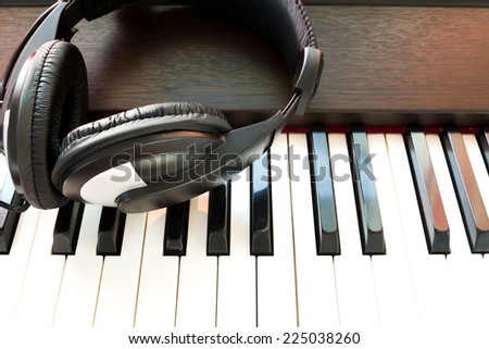 Headphone on piano keyboard. Art background.