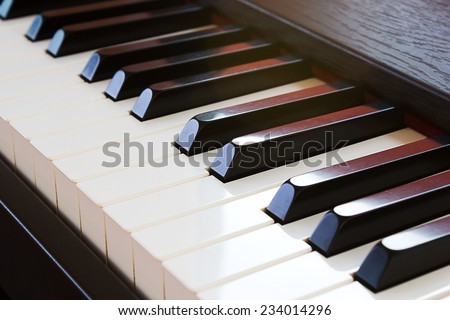 Closeup piano keyboard. Sunlight through in a part of keyboard.
