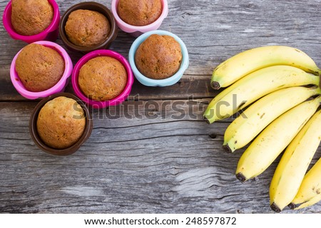 Banana cup cake in colorful baking pan (silicone)  and banana on wooden table. Top view.