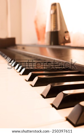 Abstract and color filter background. Closeup piano keyboard with metronome background.