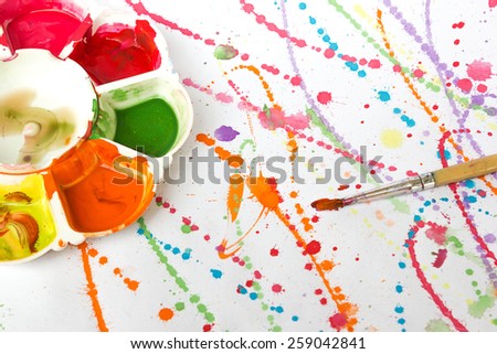 Watercolor paint tray with brush on painting background. Art and abstract background.