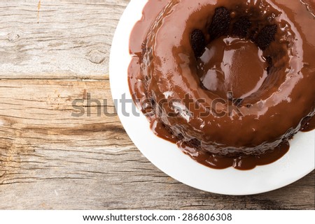 Chocolate cake with chocolate sauce on white plate. On wood table and Top view. Home made.