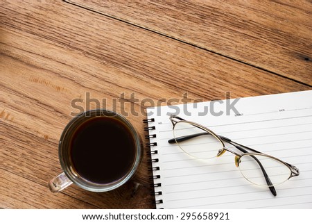Concept background of business and education. Black coffee, eye glasses and notebook. Top view and space area.