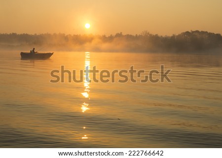 angler catching fish on a boat in the fog