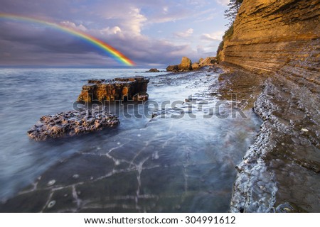 Rainbow over the cliff after passing an evening storm