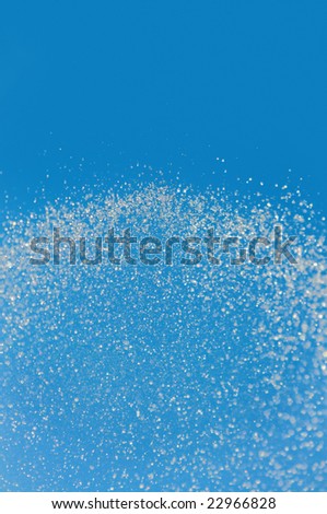 Luminous water explosion on azure background. A joyful outburst of a million of water crystals.