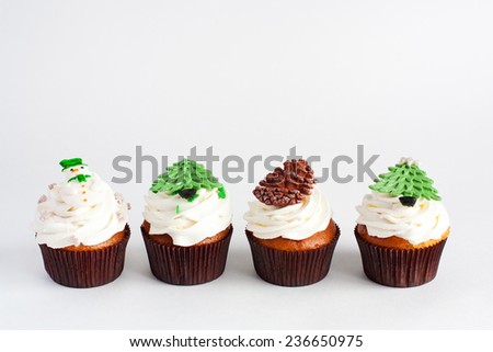 Decorated new year cupcakes standing in a row on white background