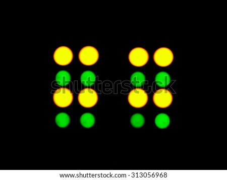 abstract blurred green and yellow LED flashing circles on a black background