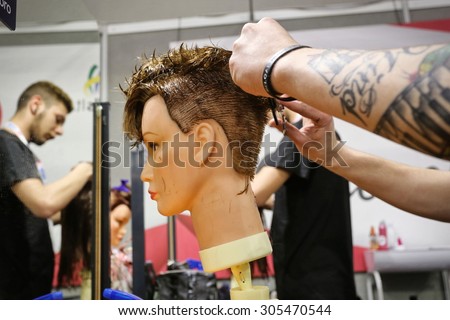 MILAN, ITALY - MARCH 25, 2015:  Cutting lesson at a school for hairdressers