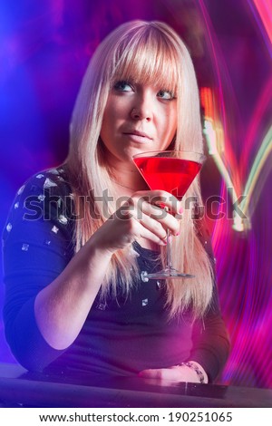 attractive lady in a club drinking a cocktail