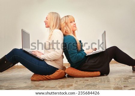 young female friends with laptop computers surfing the internet  enjoying social networking modern times connected lifestyle concept