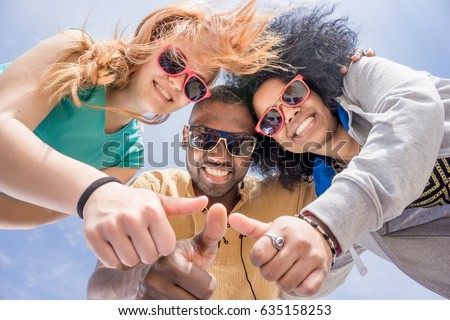 friends thumbs up. diversity and unity concept. 3 fashionable multi-ethnic young people with like gesture