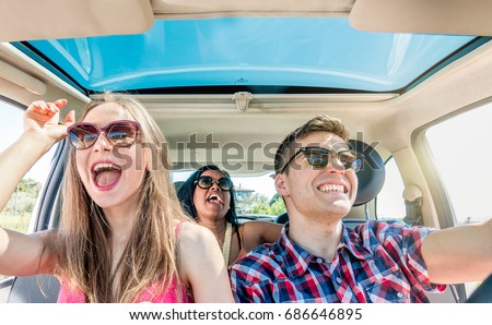 young friends in car having fun laughing singing in group and driving. happy girls with guy enjoying a car ride on sunny day. concept of diversity youth fun friendship and carefree lifestyle.