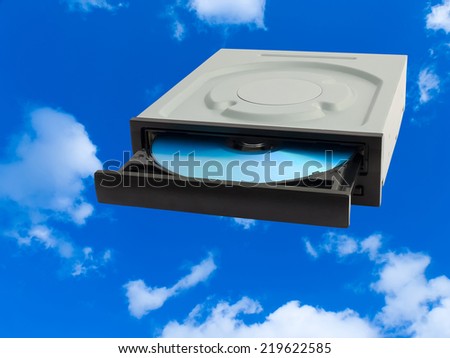 DVD driver opened to show disc against the sky (cloud technology concept).