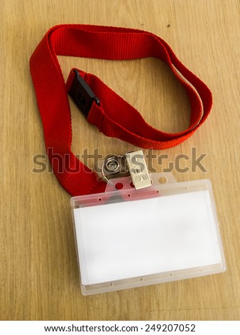 Identity card with red strap on wooden table