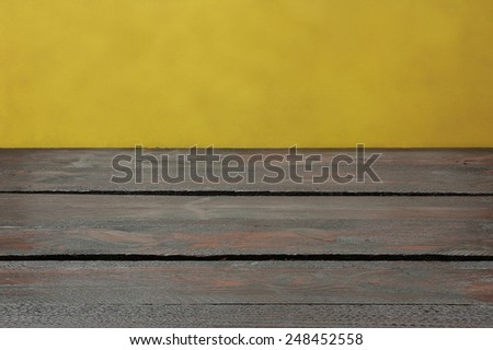Background with wooden table and yellow wallpaper
