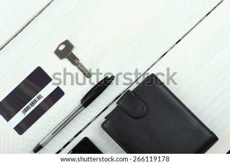 Men\'s wallet, phone, keys and card on wooden table