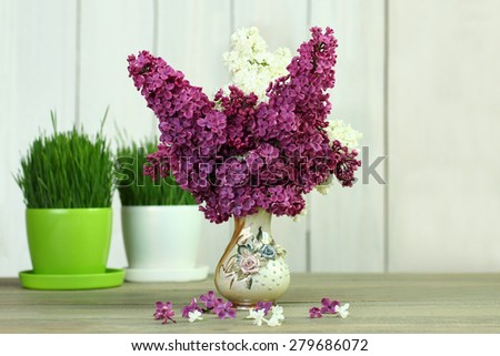 lilacs in a vase on a wooden background
