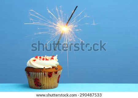 cupcake with sparkler against a blue background