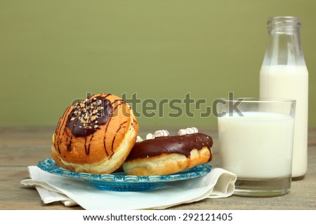 Donuts and glass of milk on wooden background