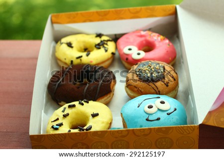 Fresh donuts in a box on a background of nature