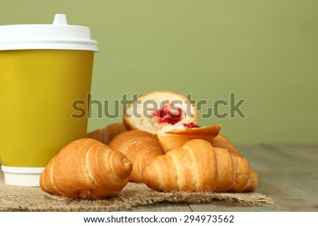 Croissants and coffee-to-go on the wooden background