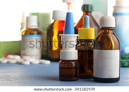 pills and bottles of cold medicine on a blue wooden table on white background