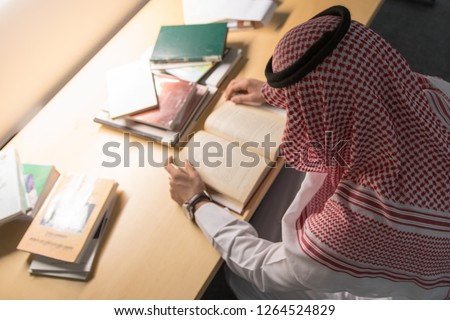Saudi Arabian Man Reading a Book in The Library