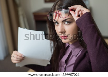 She lifted her glasses and holding a piece of paper