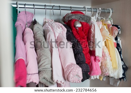 baby clothes hanging on the rack in the closet