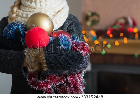 Girl in gloves holds a Christmas decoration