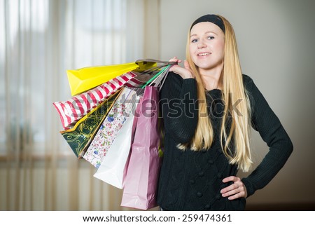 Pretty young woman holding shopping bags at home. Woman came home from the shopping